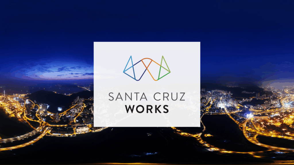 Santa Cruz Works community logo over Santa Cruz city skyline at night